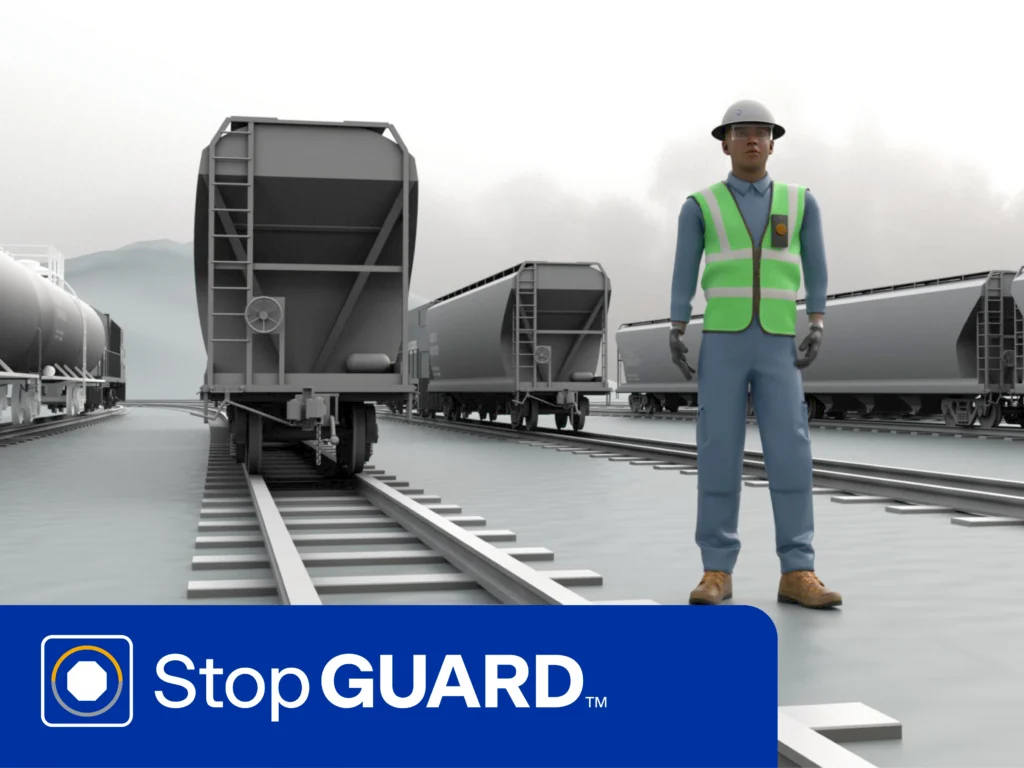 A rail worker in safety gear stands near train cars on tracks; the image includes the StopGUARD logo and branding at the bottom.