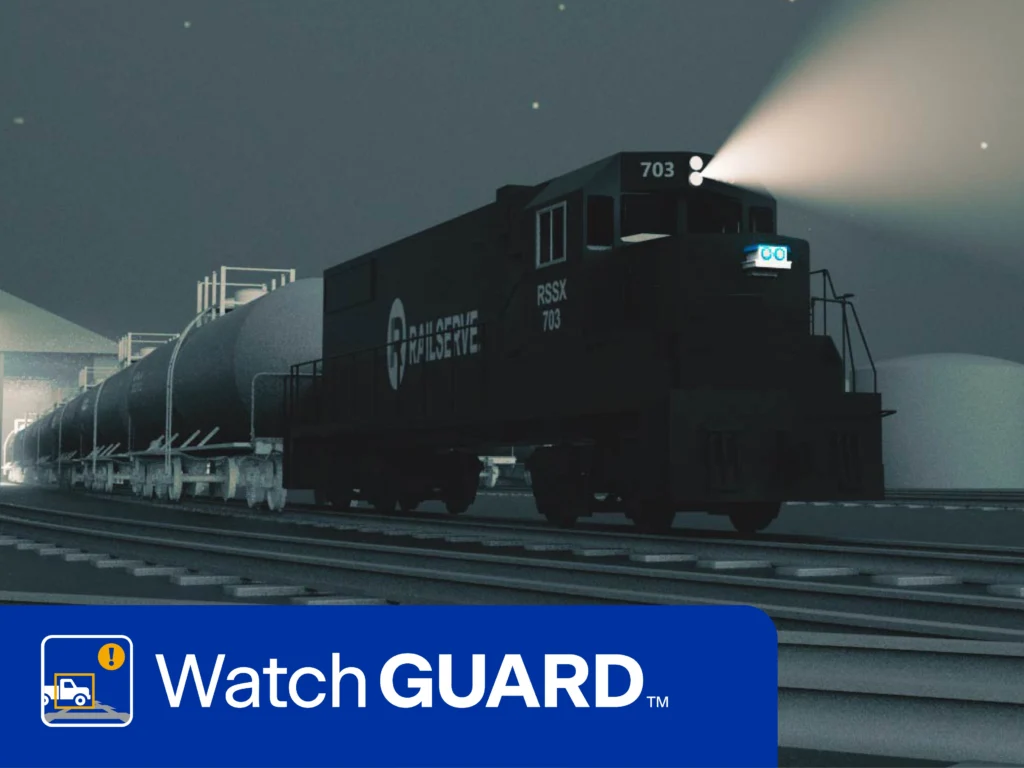 A freight train travels along railroad tracks at night with headlights on; the WatchGuard logo appears at the bottom of the image.